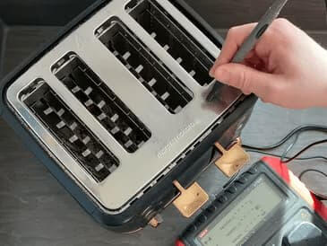 Portable appliance testings Morphy Richards four-slot toaster being tested with an earth probe.